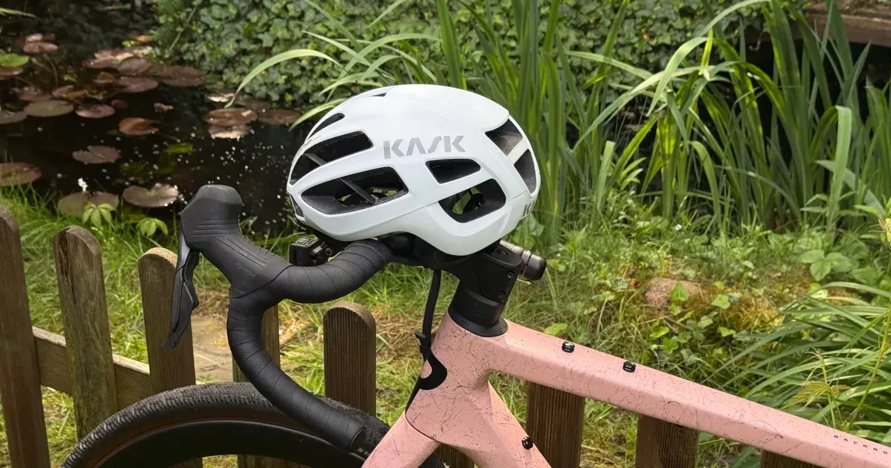 Biały kask rowerowy KASK na kierownicy różowego roweru. Przygotowany do jazdy, zgodnie z przepisami ruchu drogowego dla rowerzystów.