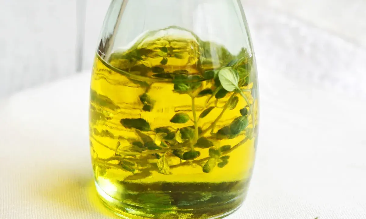 Złocisty olejek tymiankowy w szklanej butelce, z gałązkami tymianku w środku. Idealny do aromatyzowania potraw. Jak stosować?