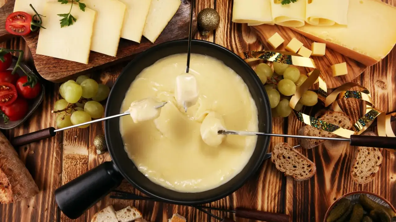 Fondue au fromage, une des spécialités d'Auvergne, accompagnée de pain, raisins et tomates cerises.