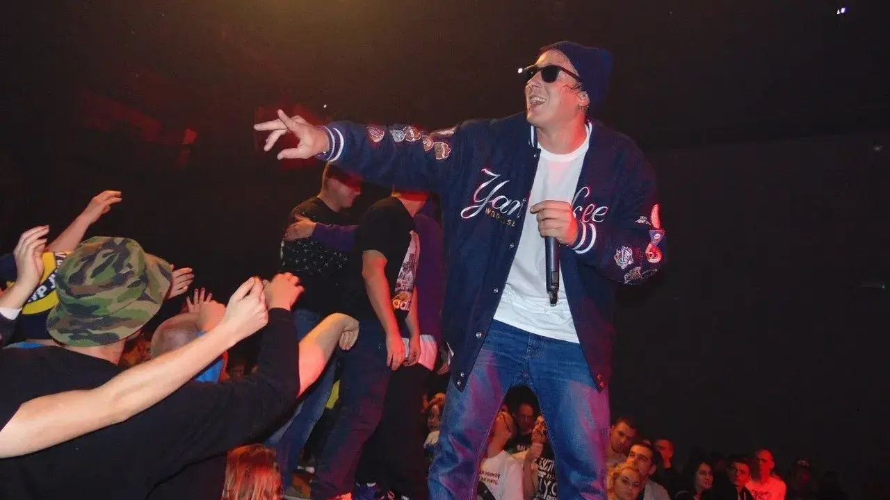 Raper na scenie w Łodzi, w bluzie z napisem "Yankee", nawija do tłumu. Hip hop łódź w najlepszym wydaniu!