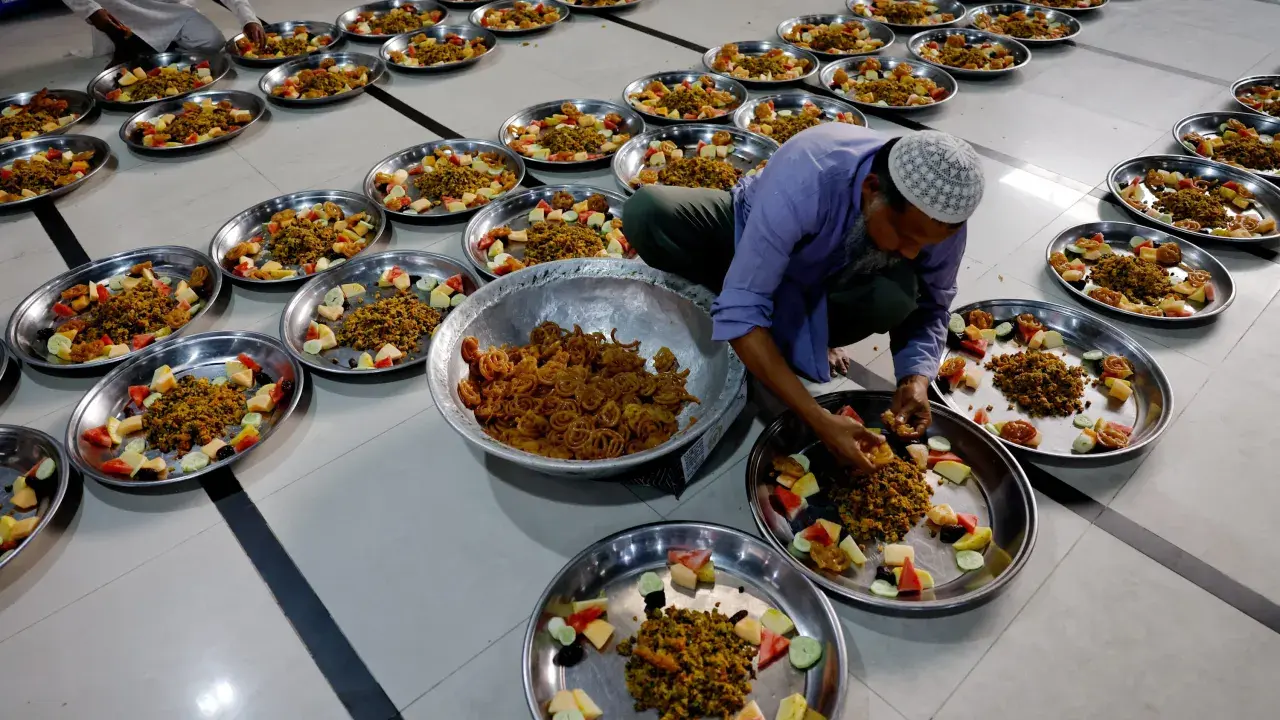 Männer bereiten Teller mit Essen und Obst für das Eid Fest vor.