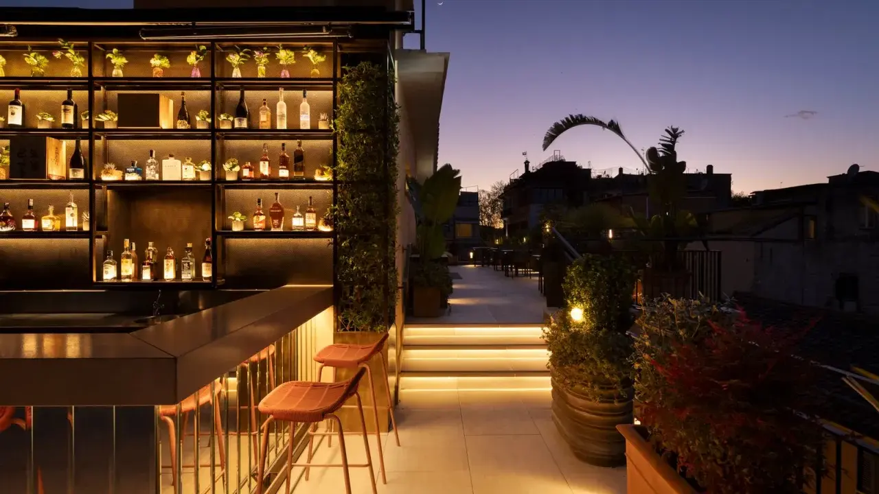 Terrazza panoramica con bar illuminato e sedie, ideale per scoprire le cose da fare a Roma nel weekend.