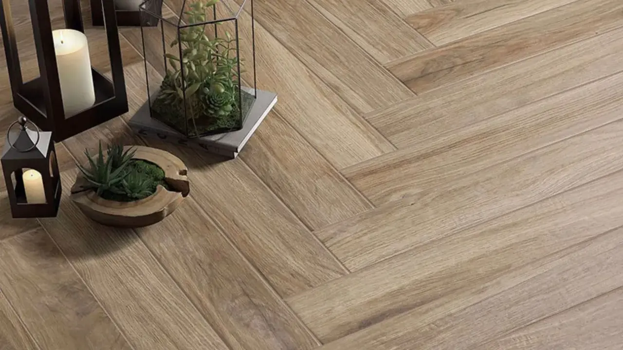 Detalles de cómo colocar azulejos en espiga, con velas y plantas decorativas sobre el suelo de madera.