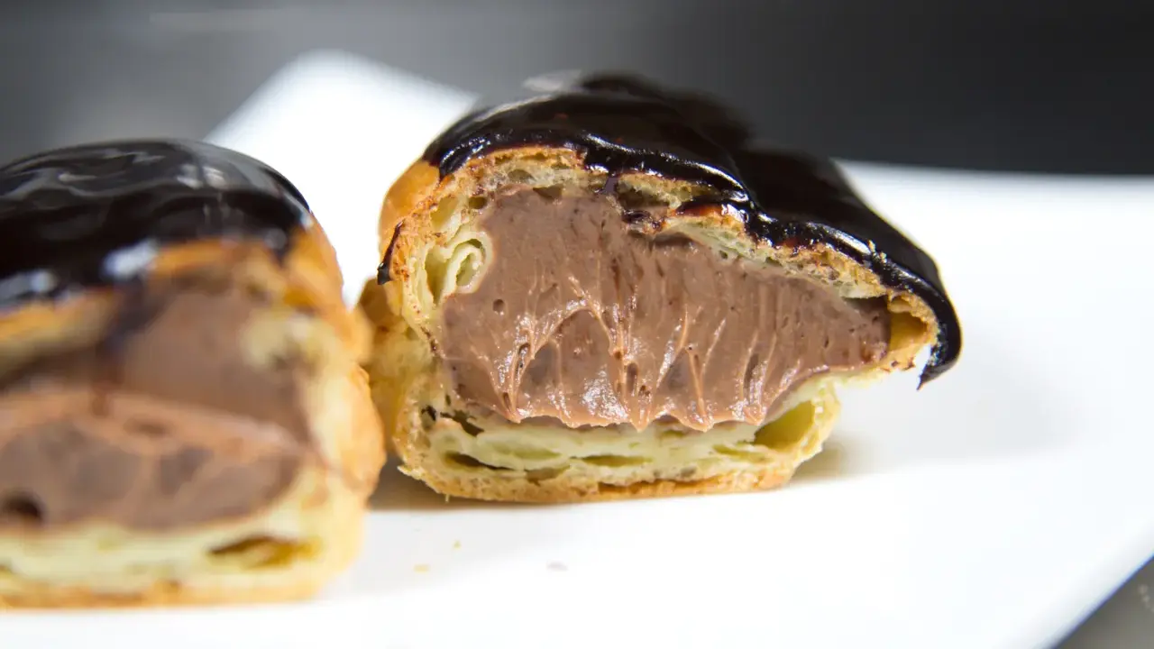 Éclairs généreusement garnis de crème pâtissière chocolat, nappés d'un glaçage brillant. Un délice gourmand.
