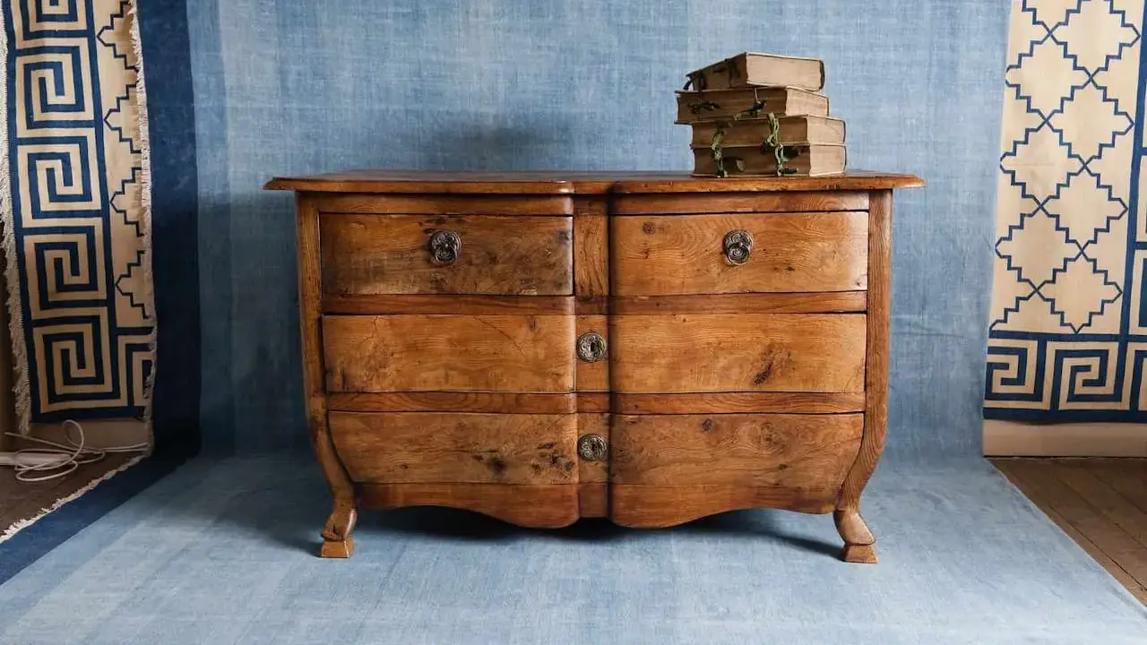 Cómoda antigua de madera, lista para restaurar muebles antiguos. Apilados libros viejos encima.