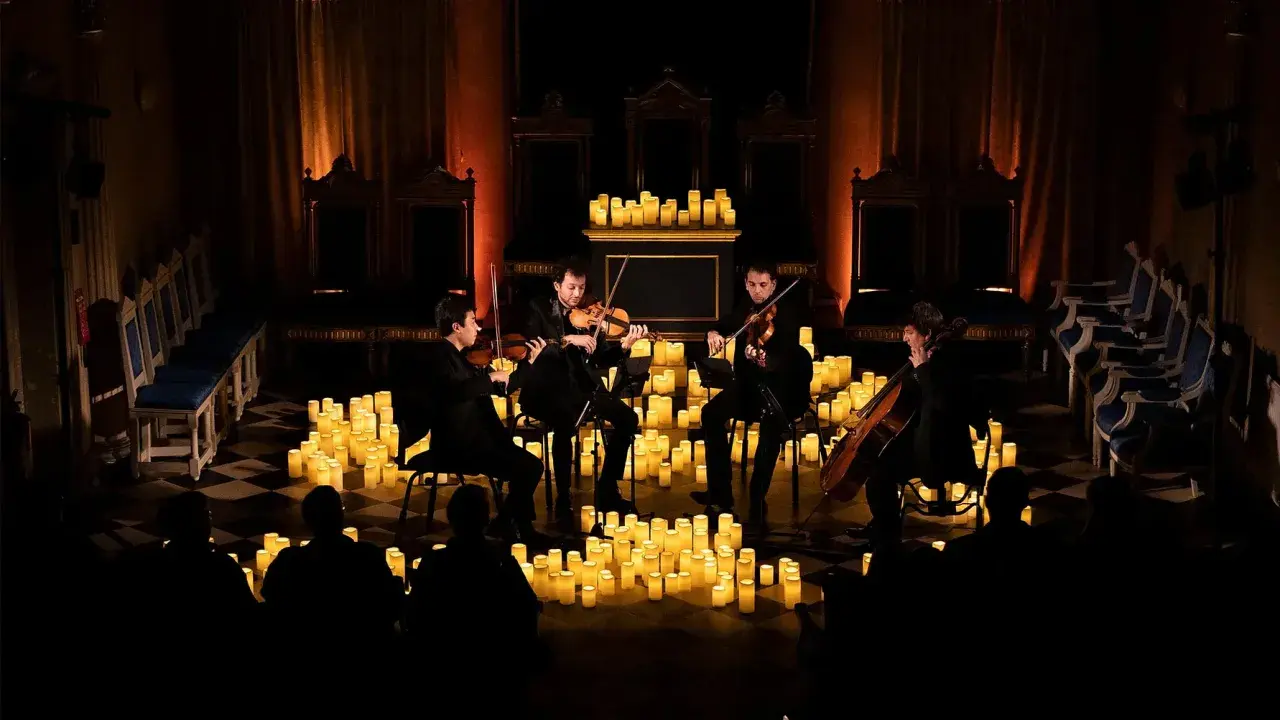 En stråkkvartett spelar bland hundratals levande ljus under en magisk candlelight concert.