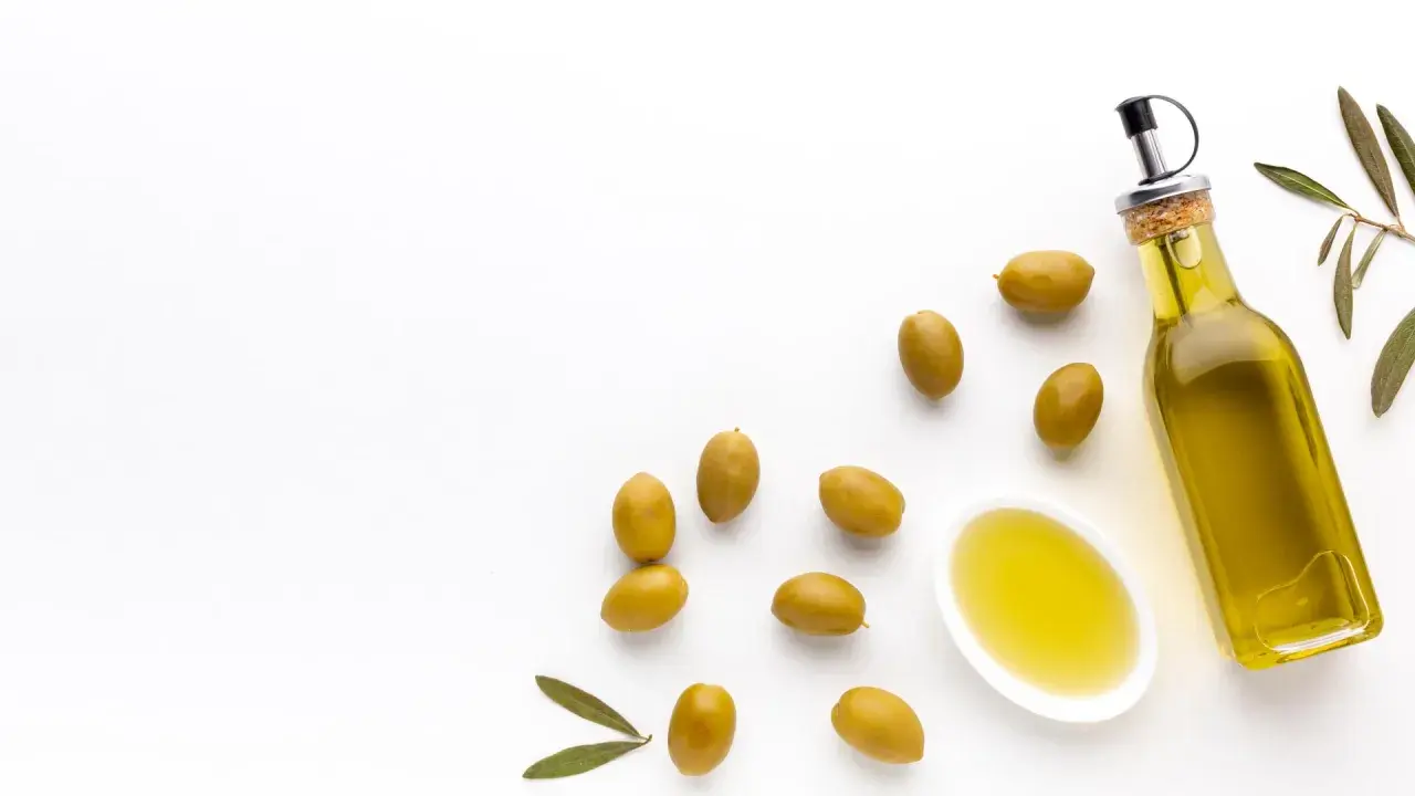 Botella de aceite de oliva virgen extra y aceitunas verdes. El mejor aceite de oliva para tomar crudo, con un sabor fresco y puro.