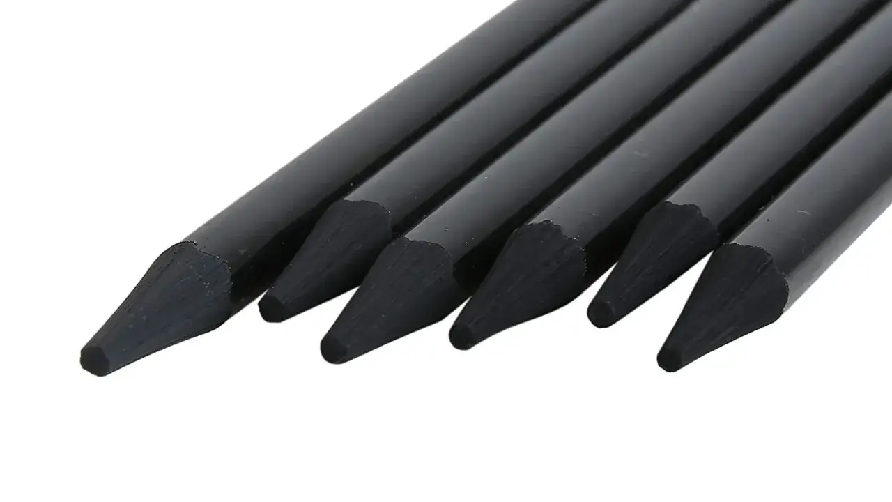 En rad svarta pennor med spetsiga stift, redo att utforska olika nivåer av blyerts hårdhet för konstnärliga uttryck.
