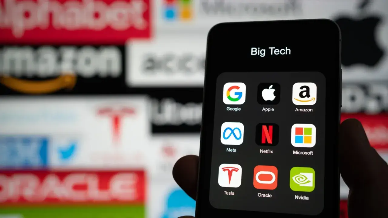 Ikona "Big Tech" na telefonie, z logotypami Google, Apple, Amazon, Meta, Netflix, Microsoft, Tesla, Oracle, Nvidia. Dyskusja o podatek cyfrowy.