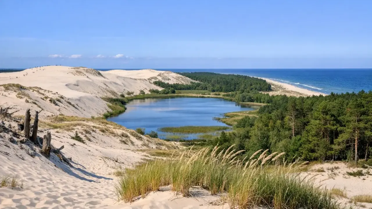 Słowiński Park Narodowy atrakcje: ruchome wydmy, jezioro Łebsko, lasy i morze. Widok z wydmy na krajobraz.