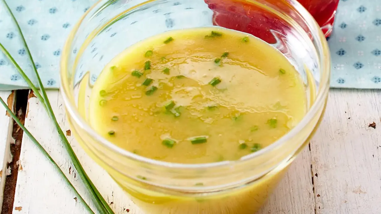 Cremige Honig-Senf-Sauce mit Schnittlauch in einer Glasschale, bereit zum Verfeinern von Salaten.