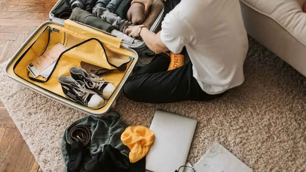Pakowanie walizki: ubrania, buty, laptop, mapa. Zastanawiasz się, co zabrać na wakacje? Oto inspiracja!