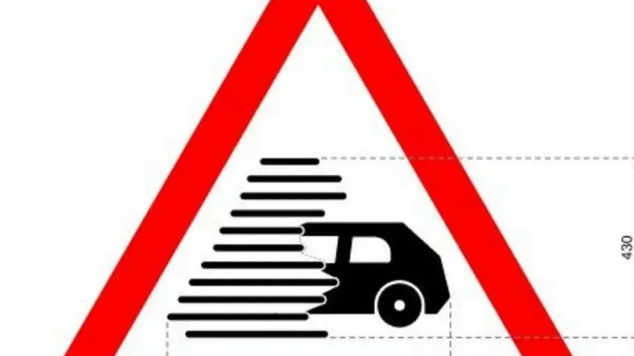 Señal de advertencia de tráfico con un coche negro en movimiento rápido, como si la regla me durara menos que antes.