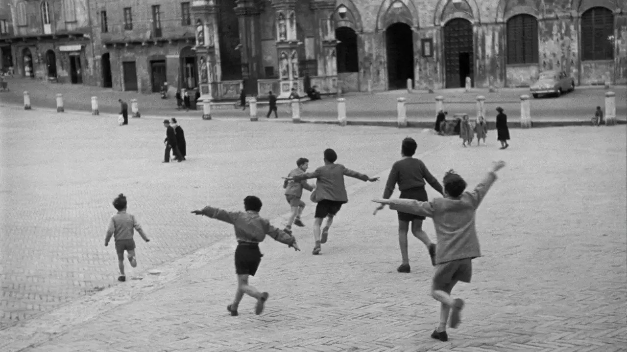 Bambini corrono in una piazza storica, un'immagine piena di movimento e gioia, perfetta come idee per foto.