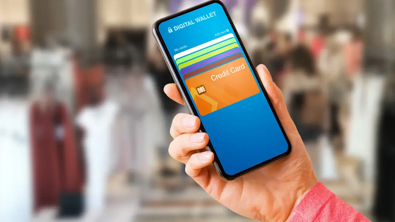 Mano sostiene un teléfono con una aplicación de wallet digital que muestra tarjetas de crédito.