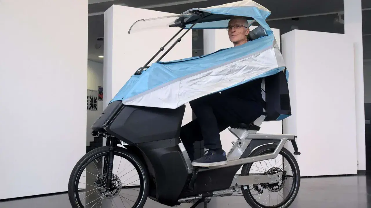 Mann auf einem E-Bike mit Dach, das an ein Auto erinnert.