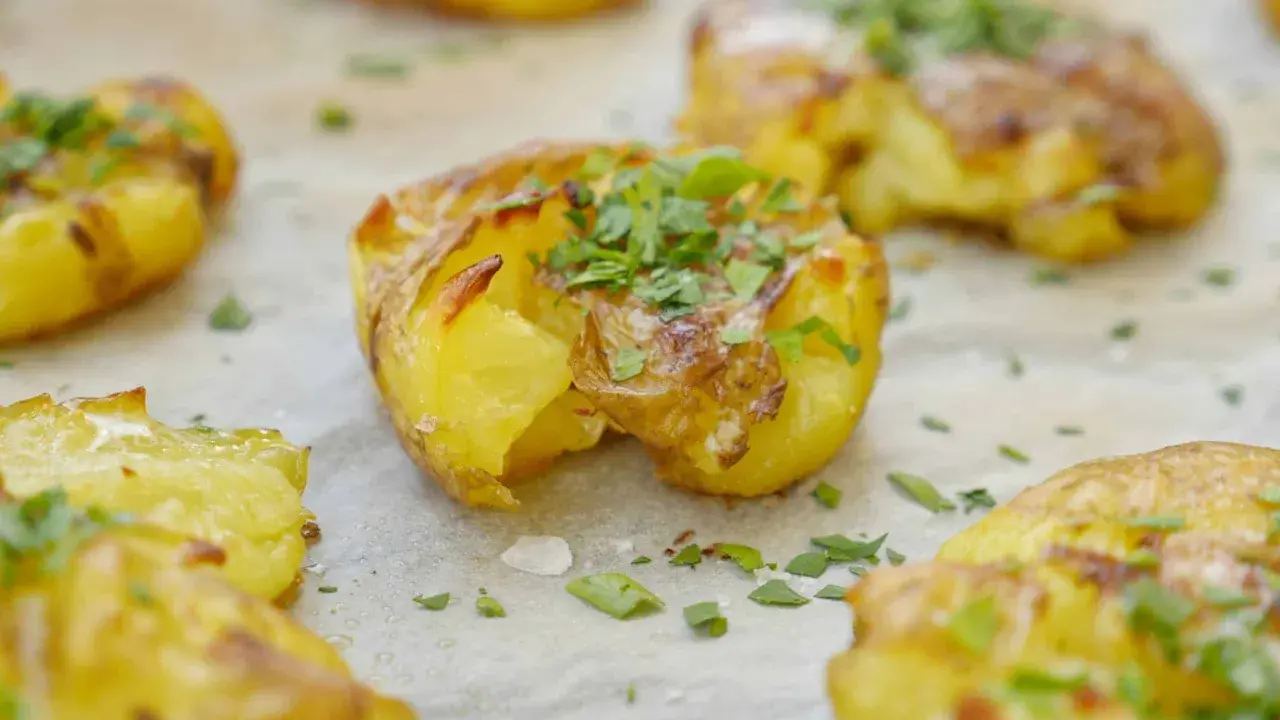 Krispiga smashed potatoes med ost och persilja, redo att serveras.