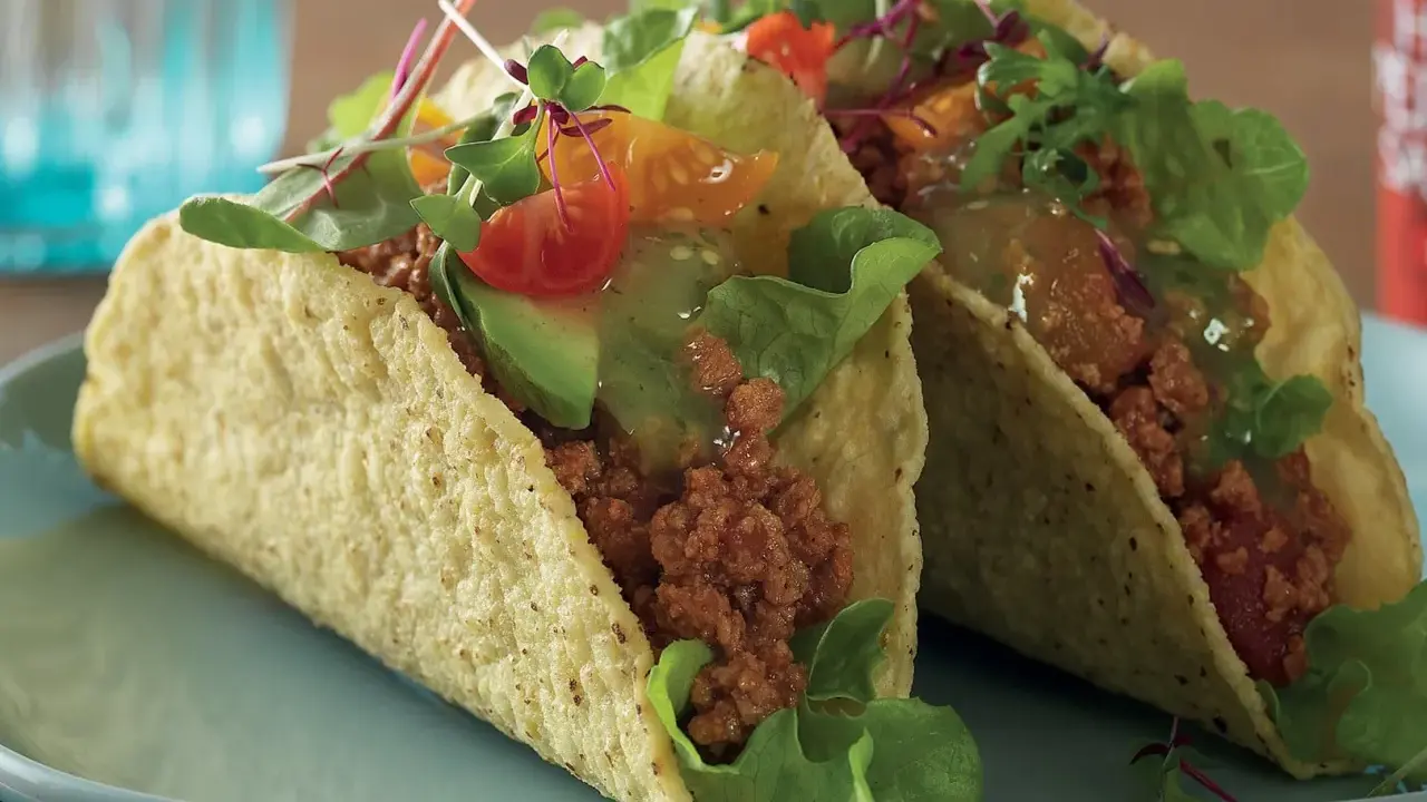 Två läckra vegetariska tacos med avokado, tomat och grönsaker. Perfekt för en snabb och smakrik måltid.
