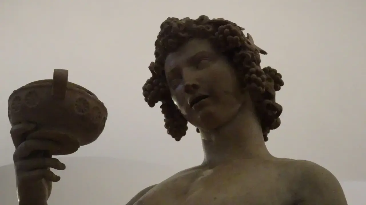Bacchus, jeune dieu du vin, couronné de grappes, tient une coupe. Une œuvre d'art inspirée par Michel-Ange.