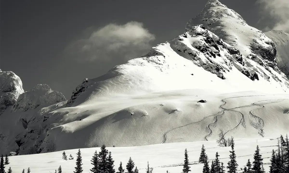 Śnieżny polski Matterhorn, majestatyczna góra w zimowej scenerii, z widocznymi śladami nart na zboczu.