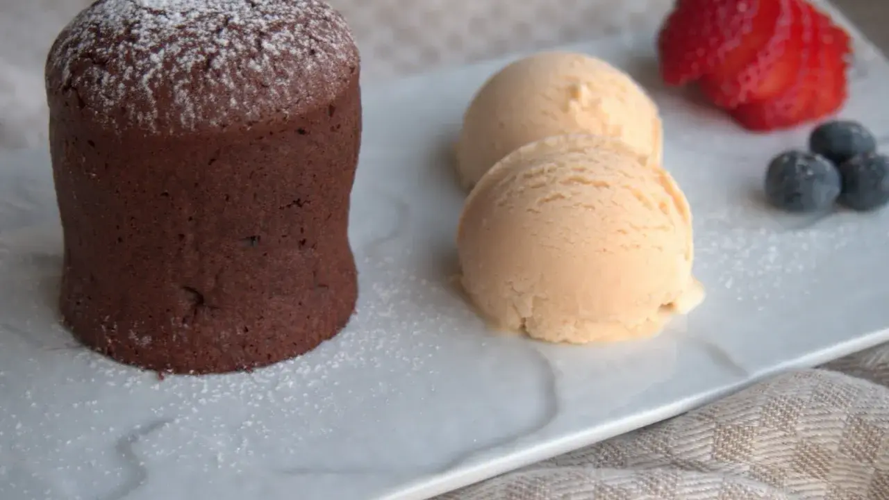 Delicioso coulant de avellana con helado cremoso, fresa y arándanos.
