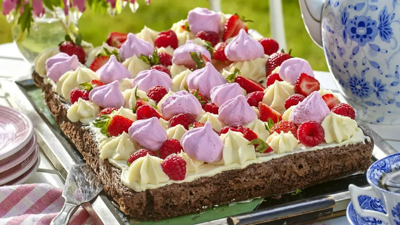 Enkel tårta till många, dekorerad med grädde, jordgubbar, hallon och maränger. Perfekt för sommarfikat!