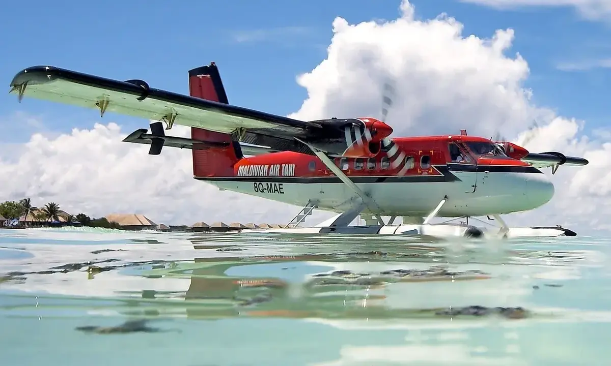 Ein rotes Twin Otter Flugzeug schwimmt auf dem Wasser vor den Malediven.