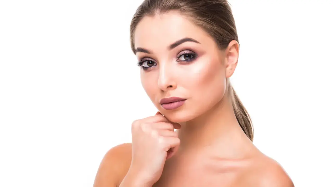 Portrait d'une jeune femme au maquillage sophistiqué, mettant en valeur ses magnifiques sourcils à la libanaise.