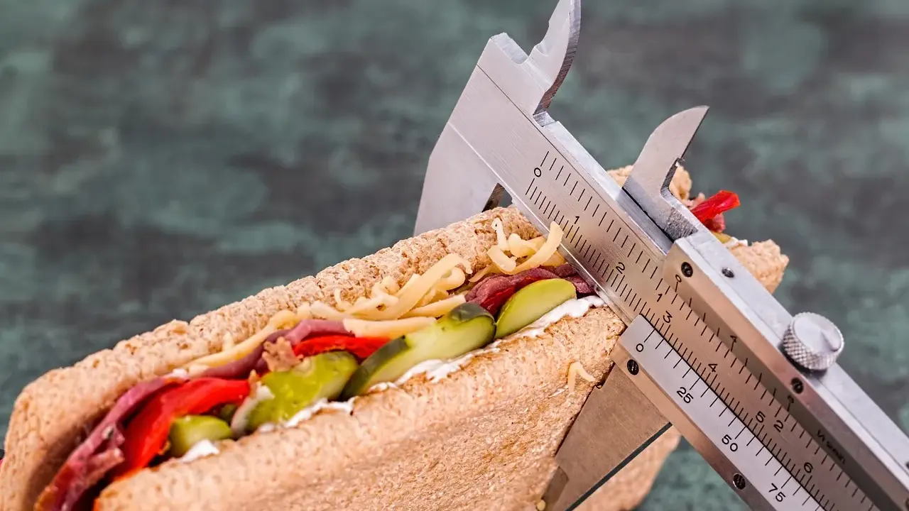 Kanapka z serem, mięsem i warzywami, mierzona suwmiarką. Wygląda na to, że ma duzo kcal.