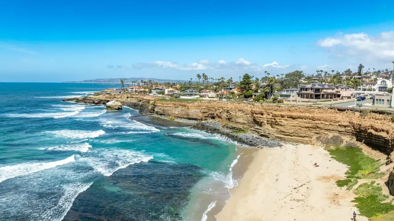 Traumhafte Küste in San Diego mit türkisfarbenem Wasser, sandigem Strand und Villen auf den Klippen.