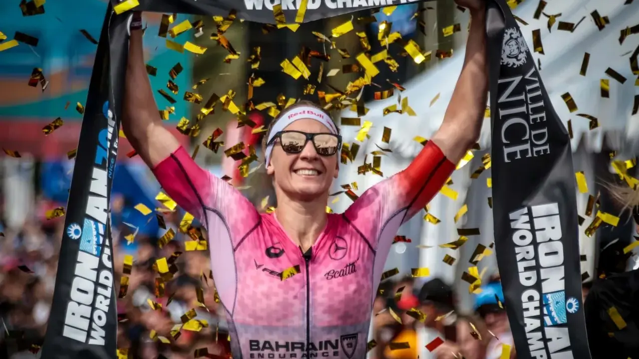 Siegerin feiert mit Konfetti und Ironman-Banner. Die hohen Ironman Anforderungen sind gemeistert.