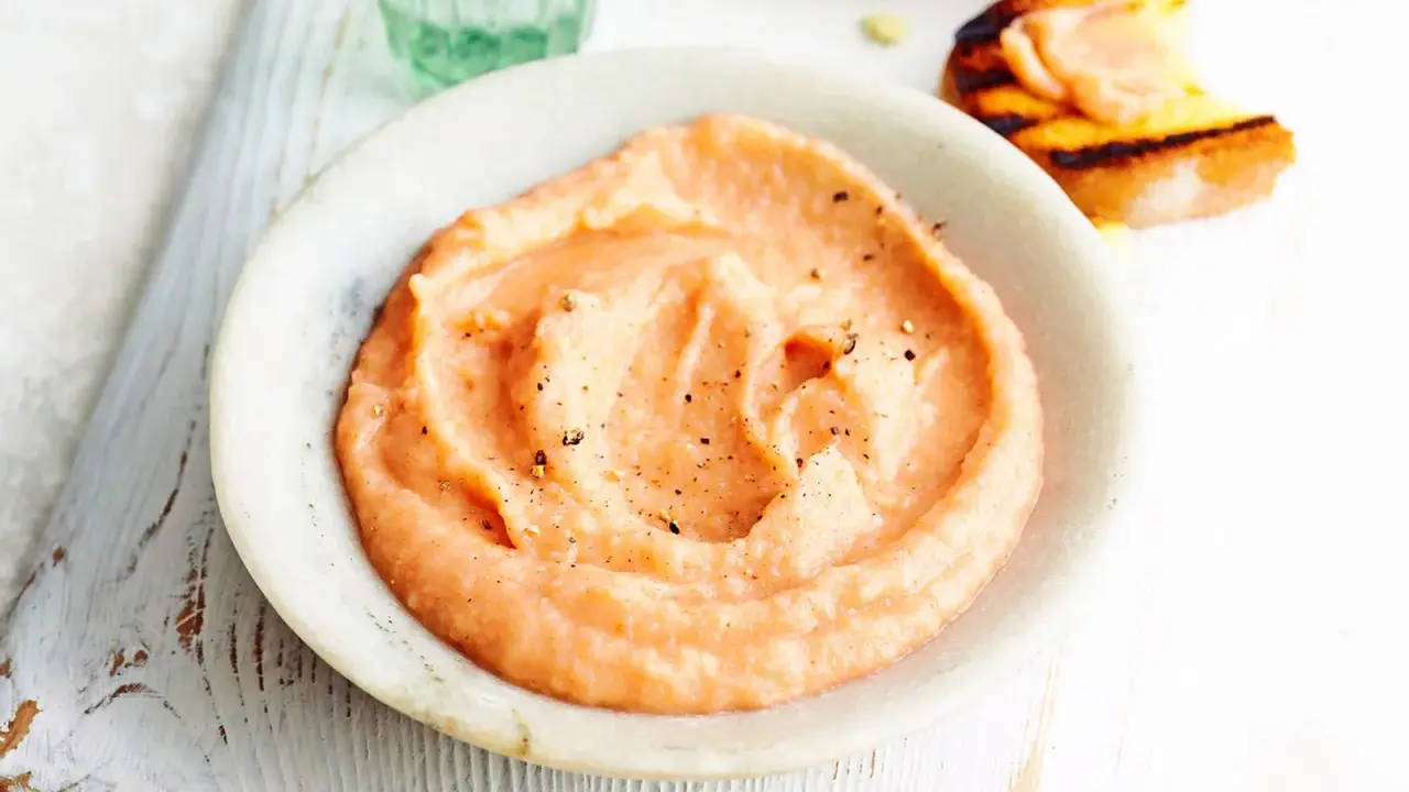 Cremiger, rosafarbener Dip mit Pfeffer bestreut, perfekt als schneller Dip zu Kartoffeln. Daneben ein geröstetes Brot mit Lachs.