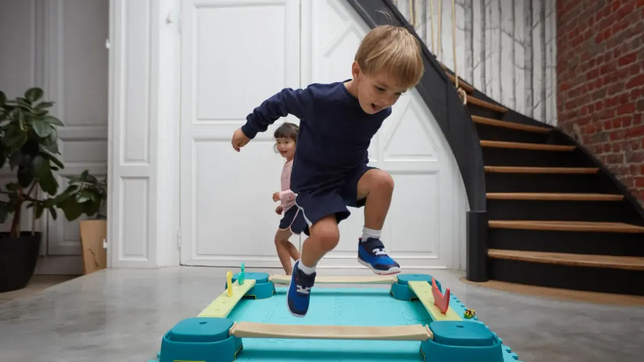 Bambini di 4 anni si divertono con la psicomotricità, saltando su un percorso a ostacoli colorato.