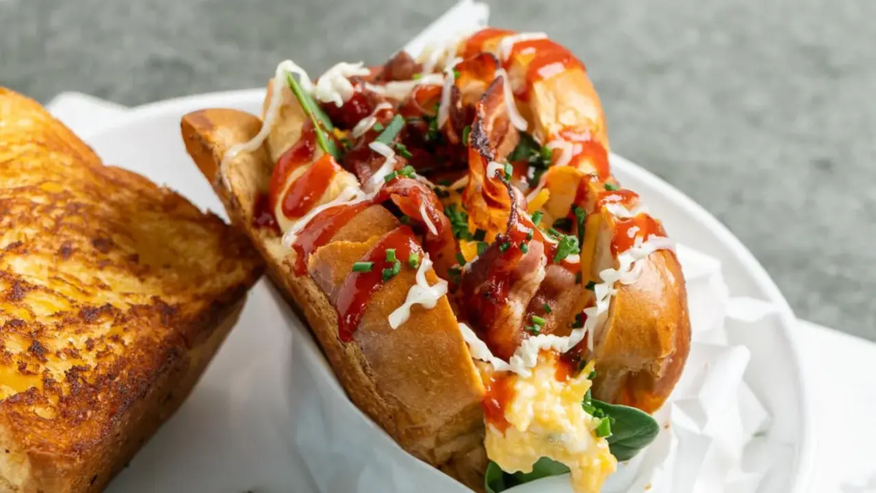 Herzhaftes **egg drop sandwich** mit Speck, Käse und Ketchup, daneben ein gegrilltes Käsebrot.