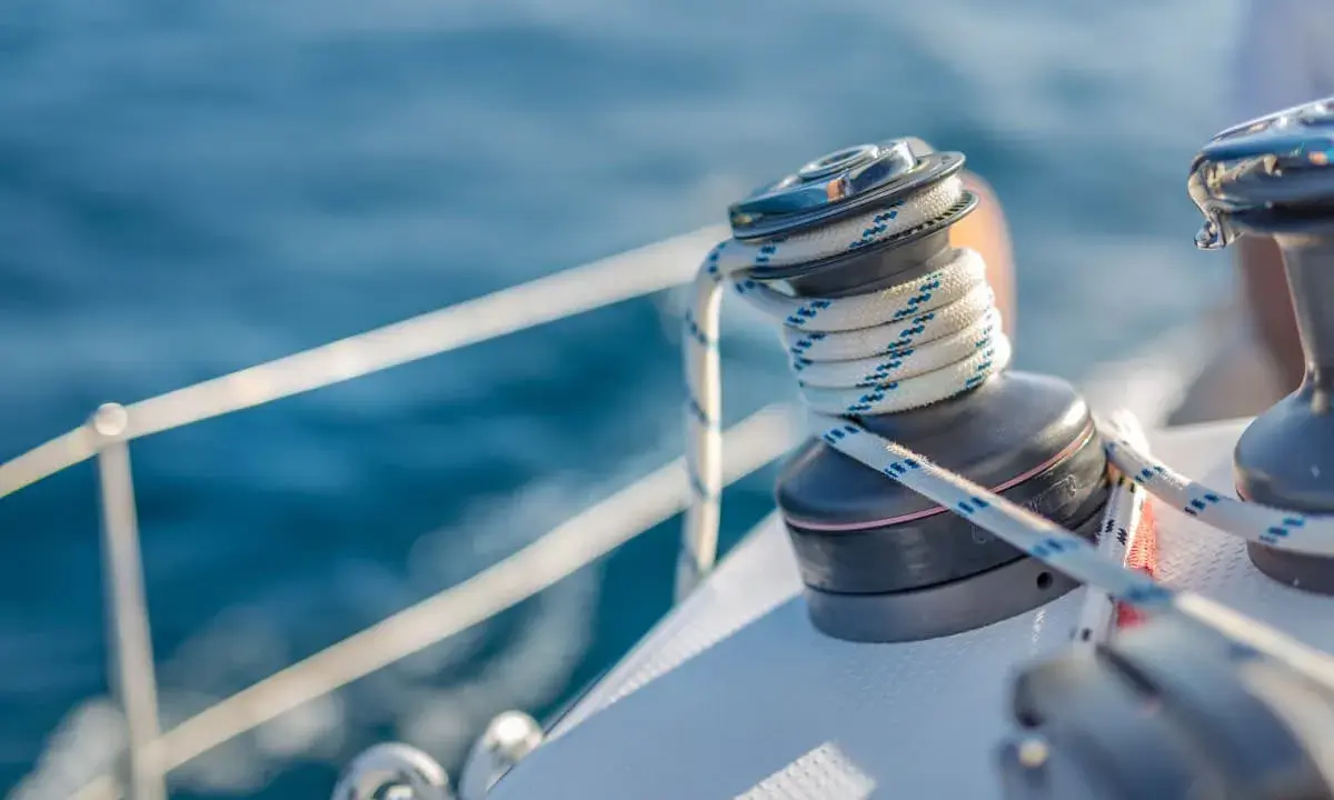 Un treuil de bateau avec une corde enroulée, un élément essentiel du vocabulaire de marin pour naviguer sur l'eau bleue.