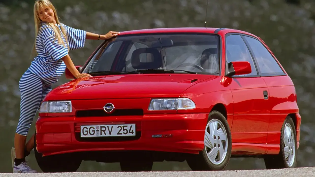 Mujer rubia posa junto a un coche histórico rojo. ¿Cuántos años tiene este coche?