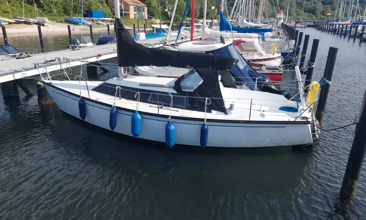Voilier blanc amarré, prêt pour l'aventure. Un Dufour 1800, parfait pour une escapade en mer.