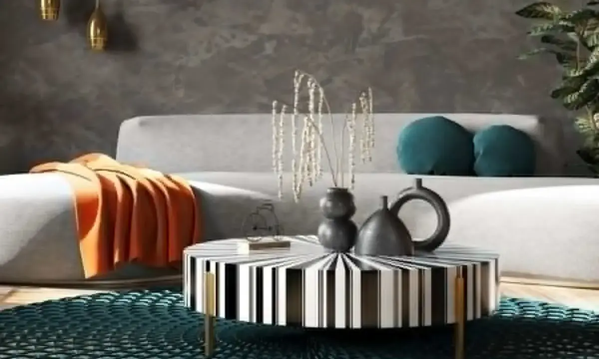 Nowoczesny salon w stylu feng shui z szarą kanapą, pomarańczowym kocem, czarno-białym stolikiem i turkusową podłogą.