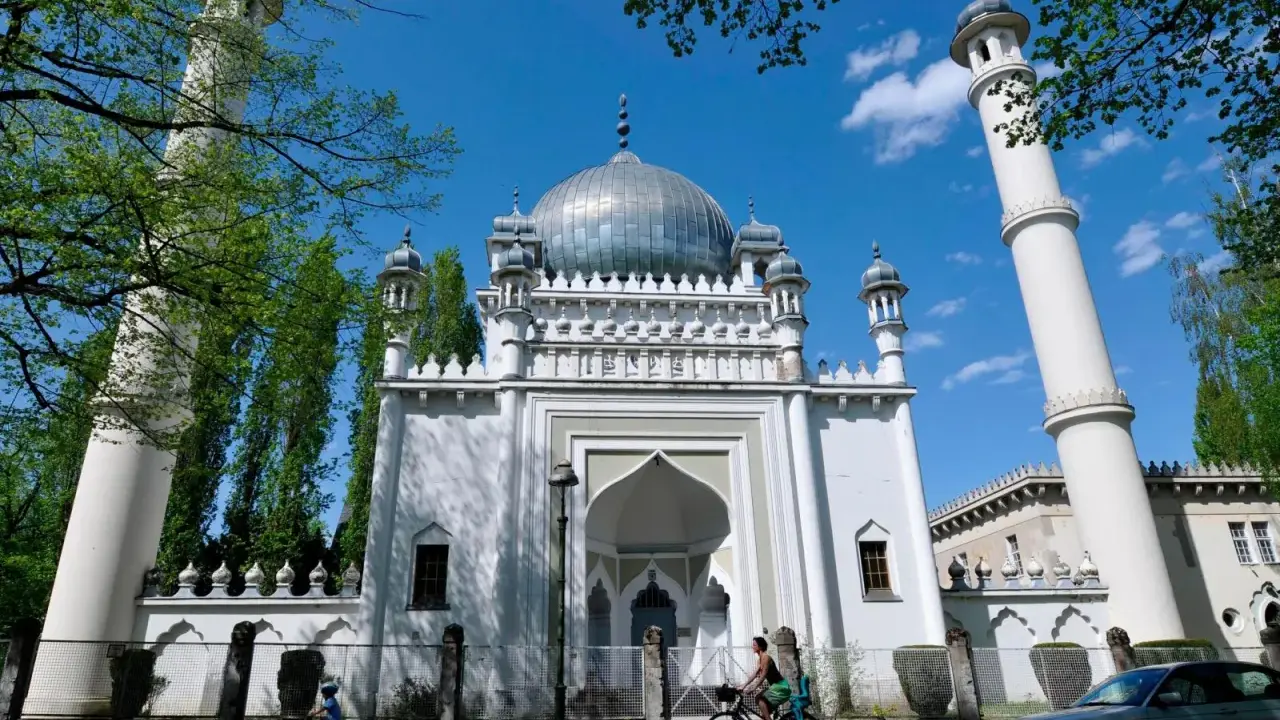 Weiße Moschee mit Kuppel und Minaretten, ein Beispiel für orientalische Architektur, im Sonnenschein.