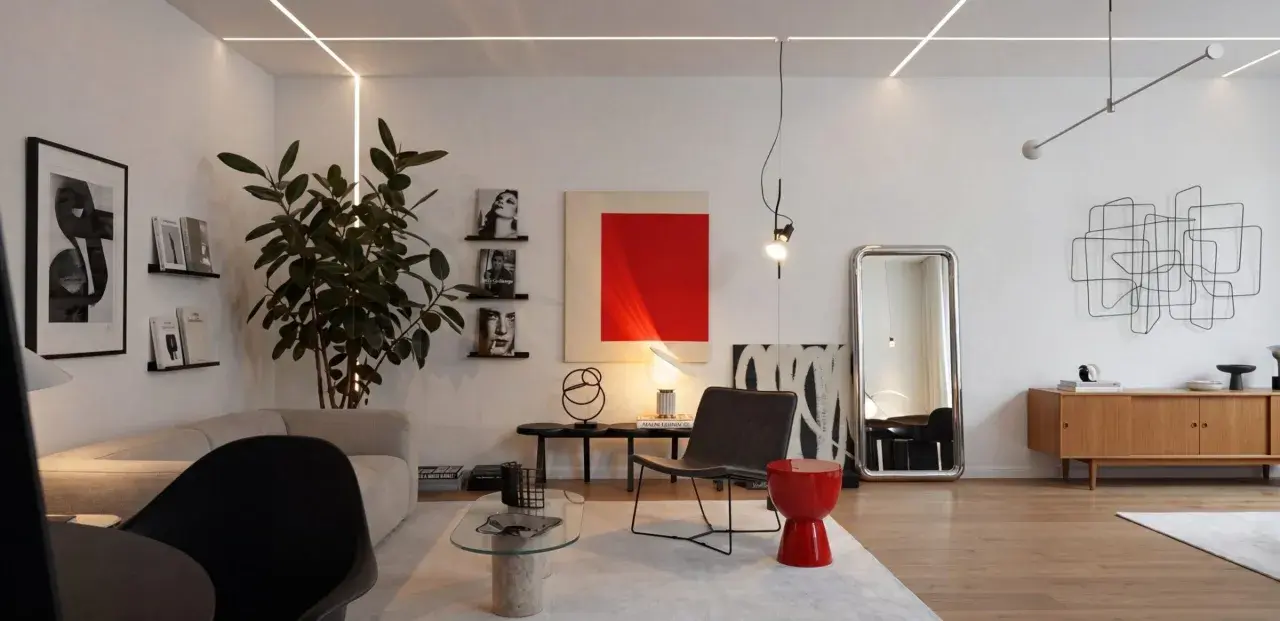 Salotto moderno con divano, poltrona, tavolino in vetro e un tocco di stile bauhaus nell'arredamento.