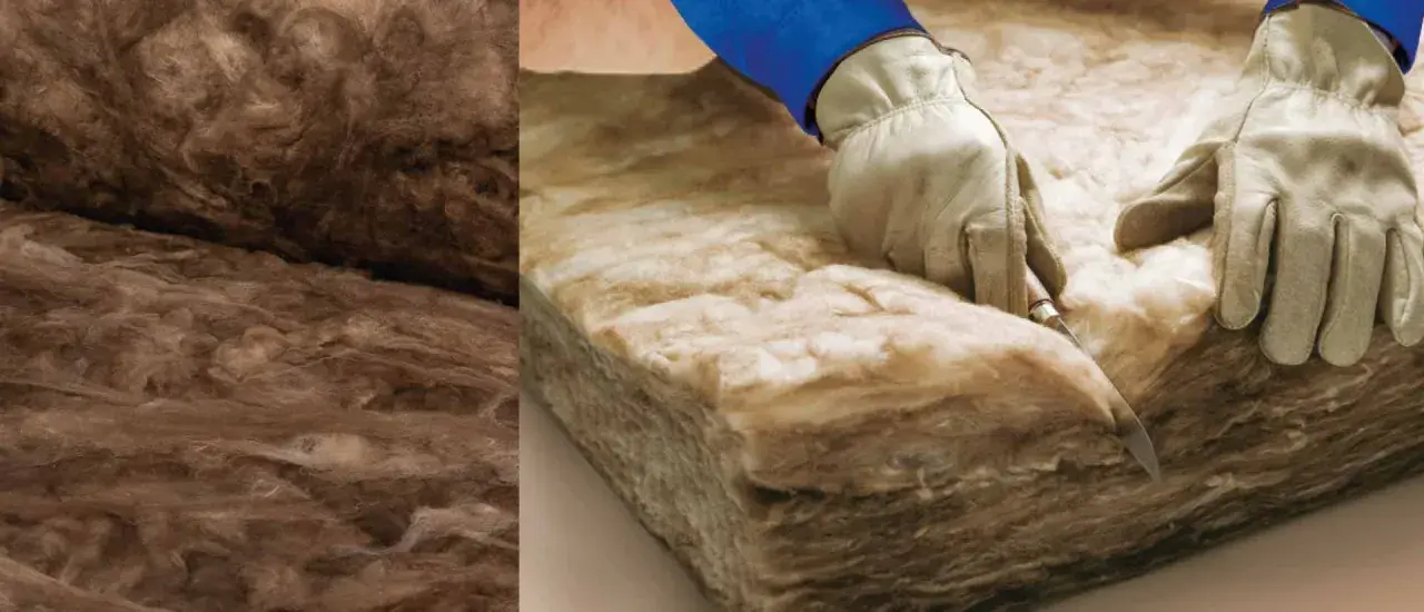 Mani guantate tagliano materiale isolante, dimostrando la legge della massa acustica per un ambiente silenzioso.