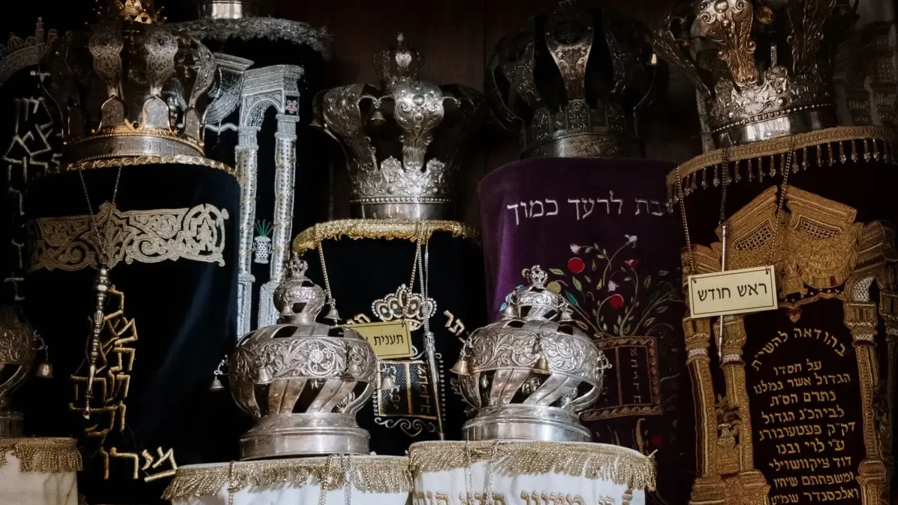 Srebrne korony i ozdobne zwoje Tory, przypominające o królewskiej chwale i mądrości z Psalmu 21.