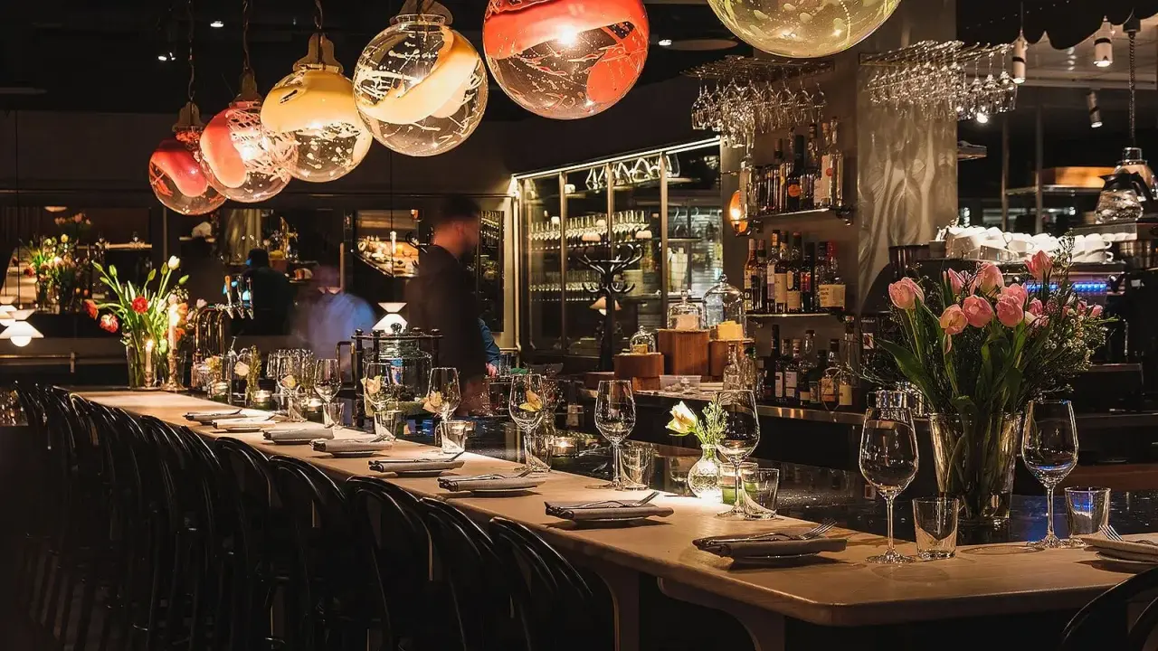 Elegant bar i en michelin restaurang Stockholm. Vackra glaslampor, blommor och uppdukade bord skapar en lyxig atmosfär.