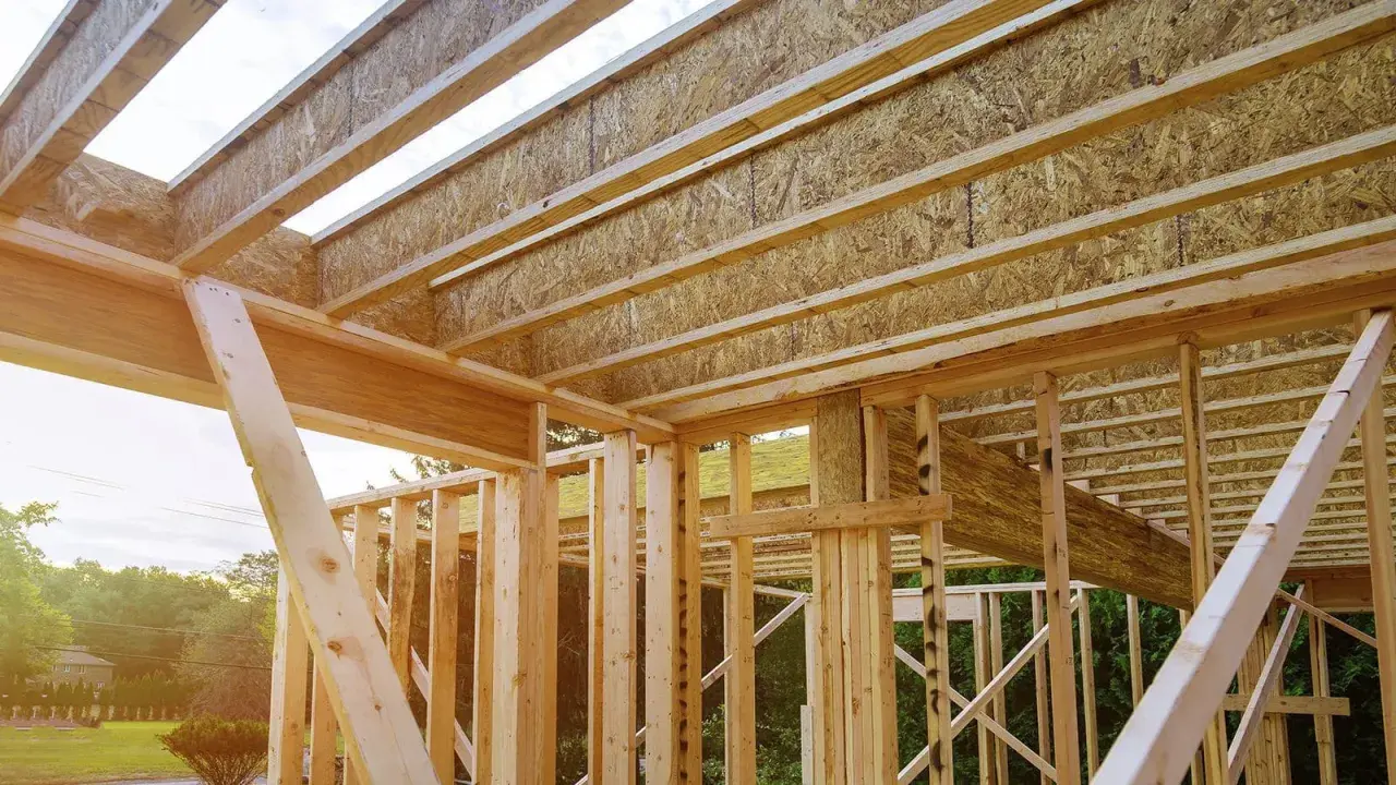 Estructura de madera de una casa en construcción, mostrando las partes de un apeo y vigas del techo.