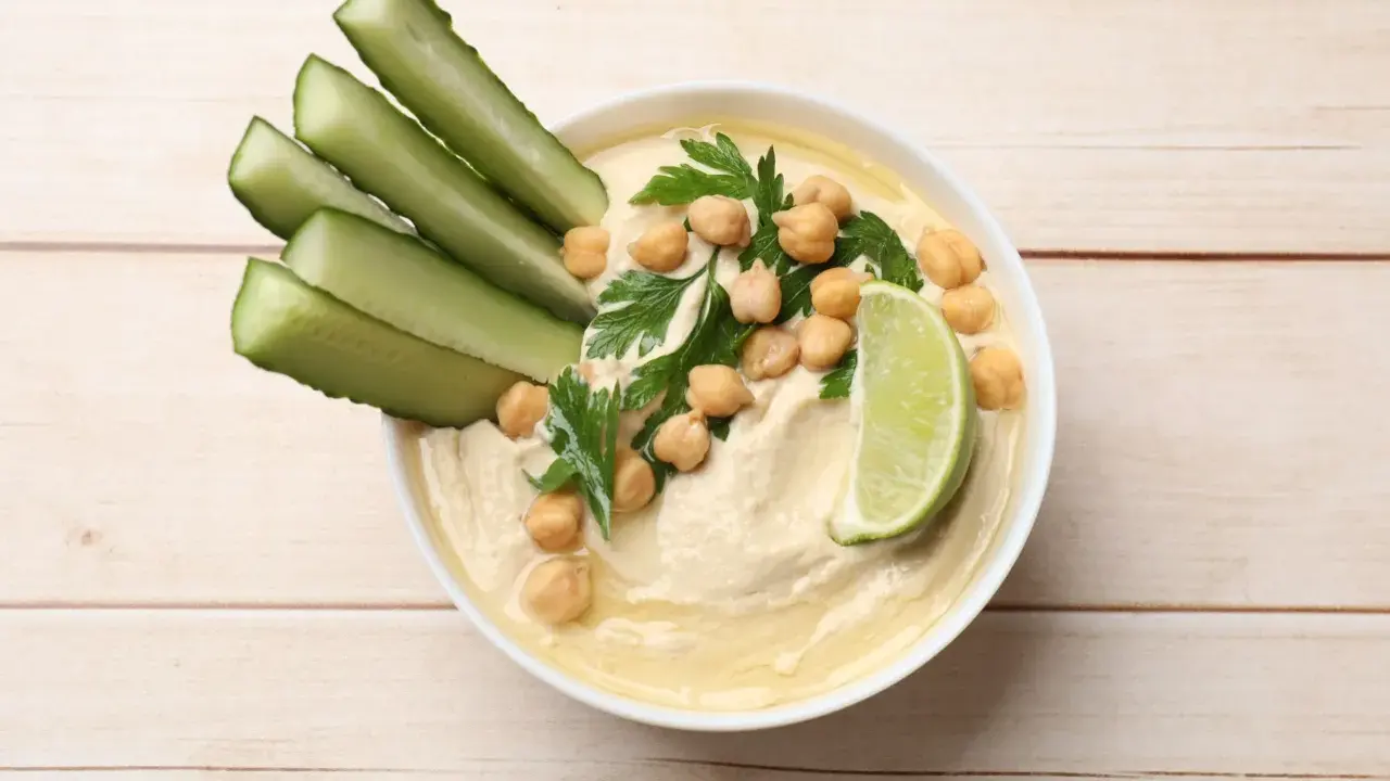 Krämig hummus med kikärtor, persilja, gurkstavar och lime. Ett enkelt hummus recept för en god dipp.