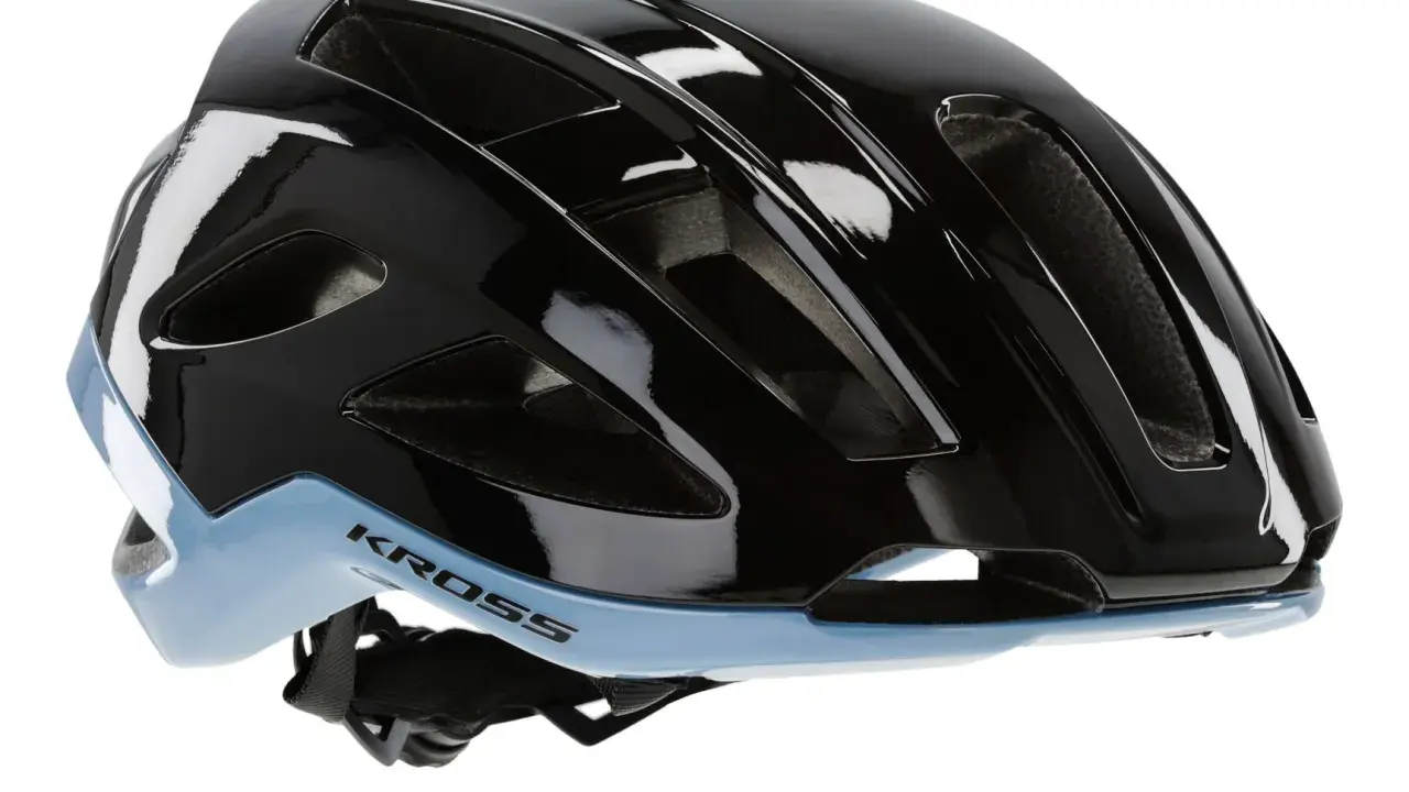 Czarny błyszczący kask rowerowy Kross z niebieskim akcentem, idealny na gravel. Zastanawiasz się, jaki kask na gravela wybrać? Ten model zapewni bezpieczeństwo i komfort.