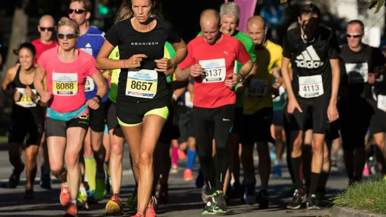 Runners in a marathon, with a woman in the foreground wearing bib number 8657.