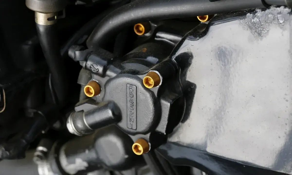 Elementy układu hydraulicznego motocykla, widoczna regulacja pedału sprzęgła hydraulicznego.