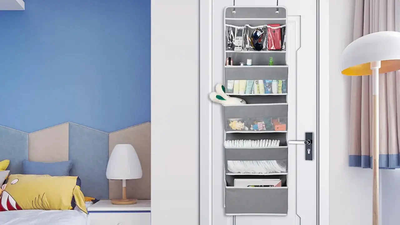 Grauer **Pocket Schrank** an der Tür mit vielen Fächern, gefüllt mit Kosmetik, Spielzeug und Windeln.