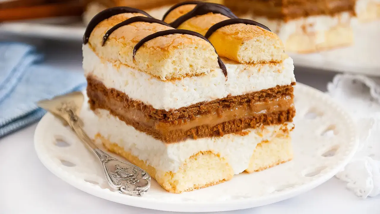 Szybkie ciasto z serkiem mascarpone, przełożone kremem i biszkoptem, ozdobione czekoladą. Idealne na deser.